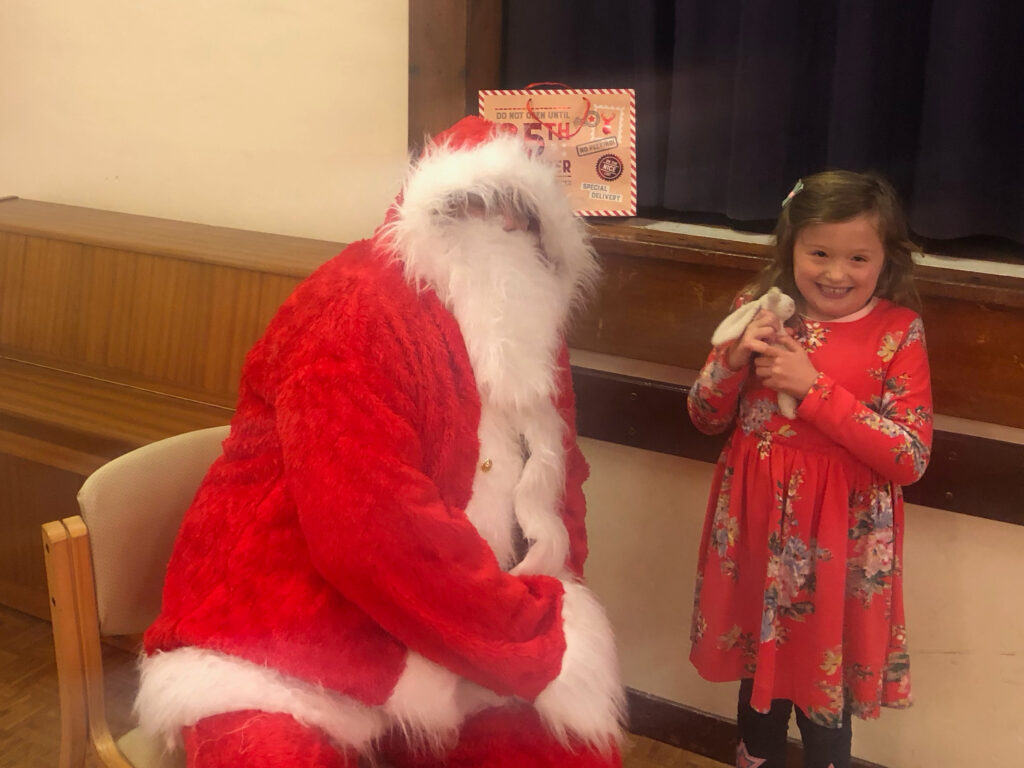 Father Christmas giving out gifts to the children at St. Margarets Church Hall 2022